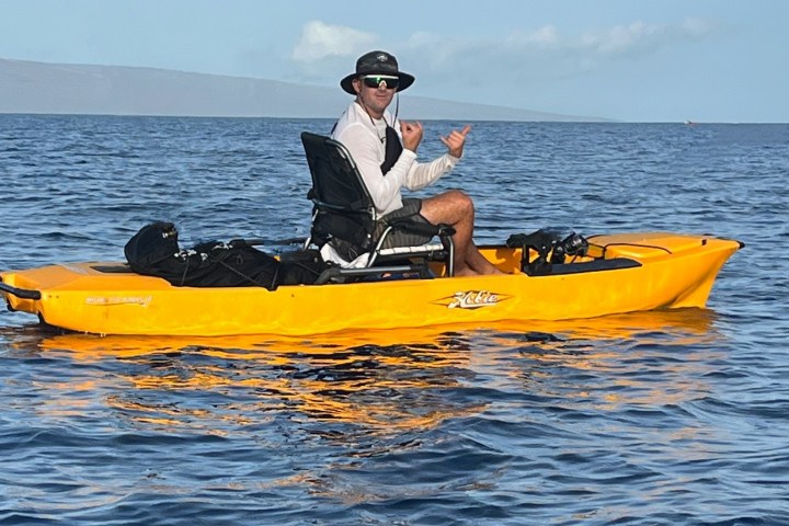 a man riding on the back of a boat in a body of water