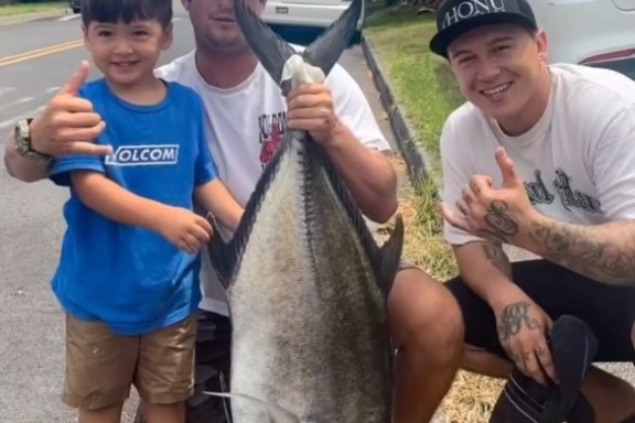 a young boy holding a fish